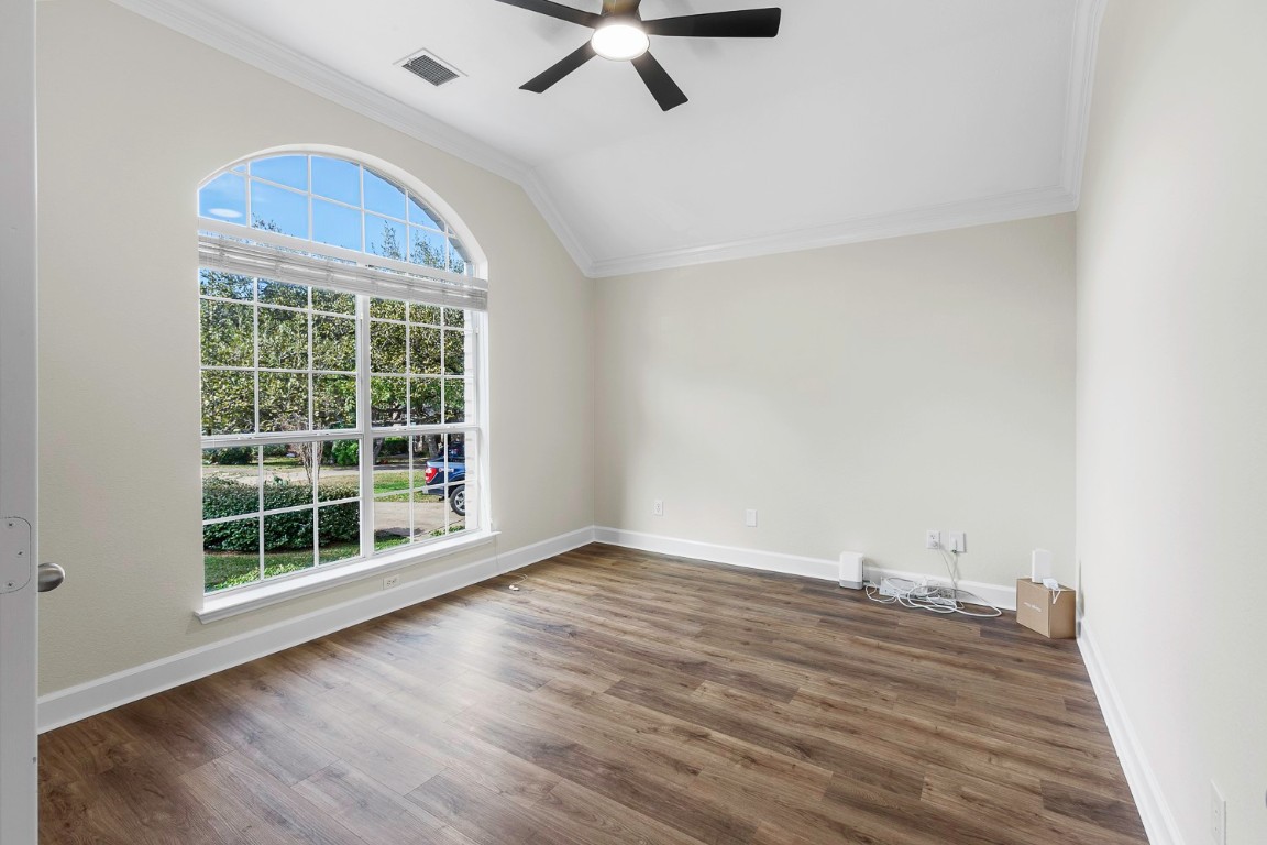 10805 Ariock Lane Austin, TX 78739 - Photo 22 of 40 Unfurnished room featuring ornamental molding, vaulted ceiling, dark wood-style flooring, and ceiling fan