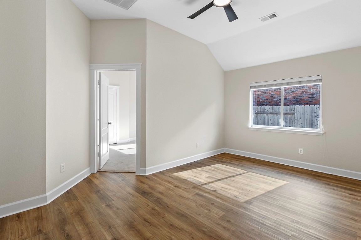 10805 Ariock Lane Austin, TX 78739 - Photo 26 of 40 Spare room featuring lofted ceiling, dark wood-style floors, and a ceiling fan