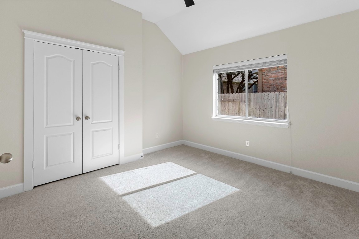 10805 Ariock Lane Austin, TX 78739 - Photo 28 of 40 Unfurnished bedroom featuring vaulted ceiling, a closet, carpet floors, and a ceiling fan