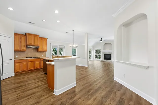 a kitchen with stainless steel appliances granite countertop a white cabinets and wooden floors