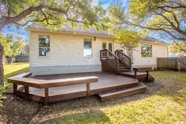 a view of trees and deck with wooden fence