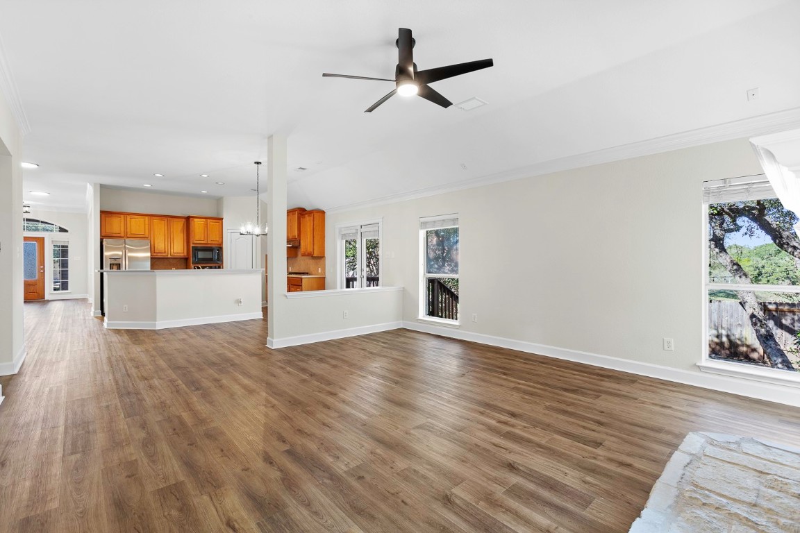 10805 Ariock Lane Austin, TX 78739 - Photo 7 of 40 Unfurnished living room featuring a chandelier, dark wood-type flooring, recessed lighting, ceiling fan, and plenty of natural light
