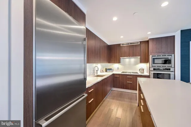 a large kitchen with kitchen island granite countertop a large counter top stainless steel appliances and cabinets