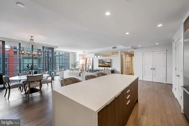 a living room with furniture a wooden floor and a large window