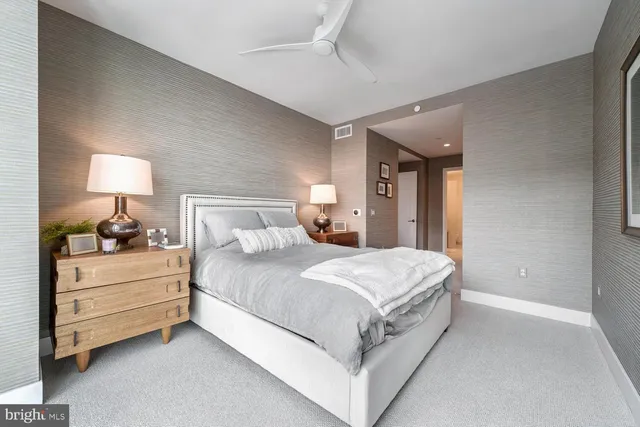 a bedroom with a bed and a lamp on dresser