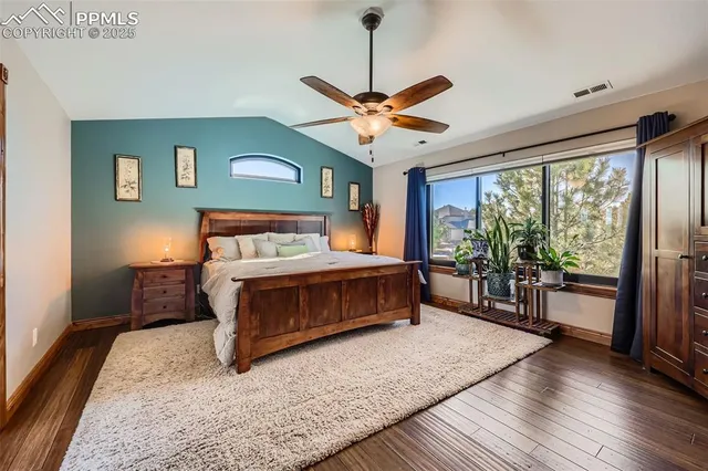 a bedroom with a bed ceiling fan and a large window