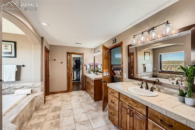 a spacious bathroom with a sink double vanity granite and a large mirror