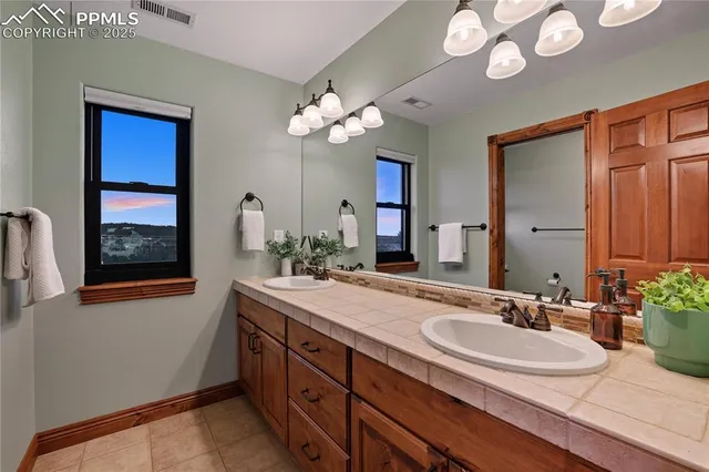 a bathroom with a granite countertop sink a large mirror and a window