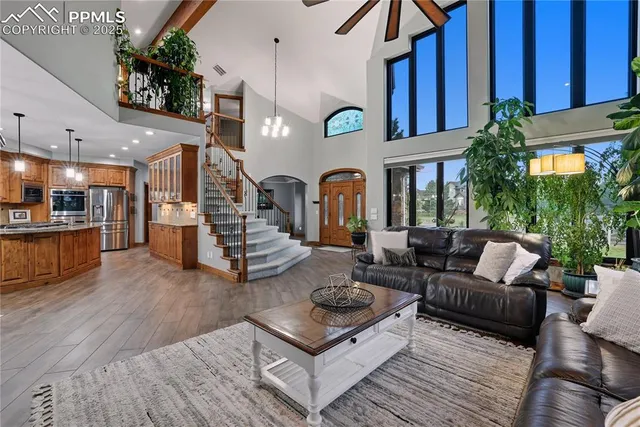 a living room with furniture kitchen view and a wooden floor