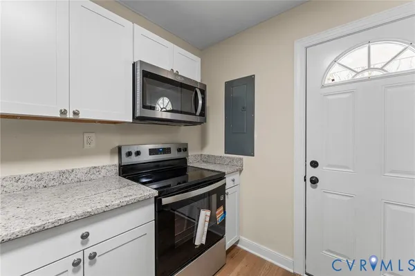 a kitchen with granite countertop white cabinets and sink