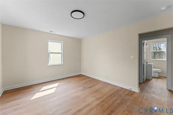 an empty room with wooden floor and a window
