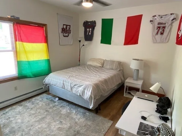 a bedroom with a bed and dresser with the window