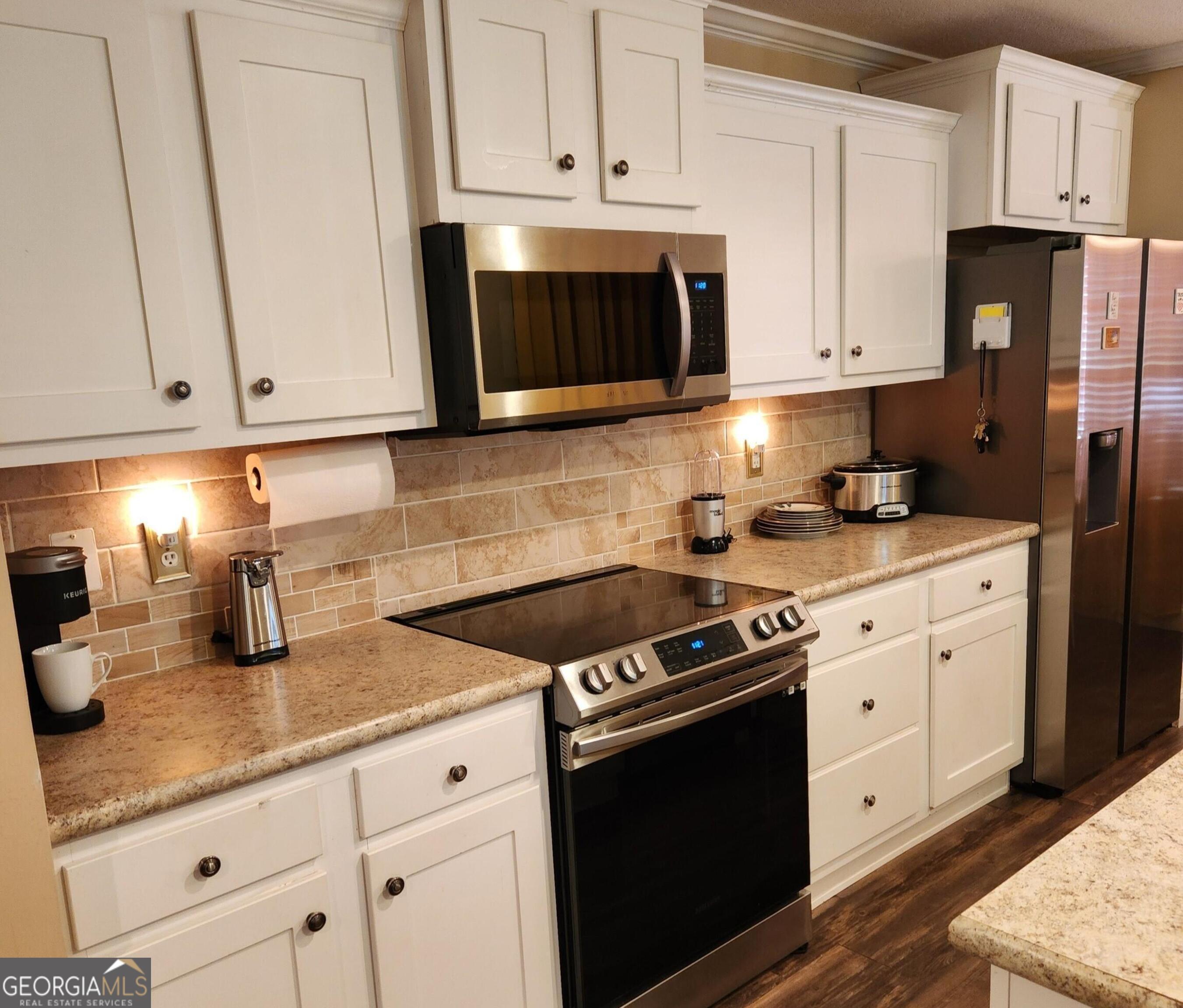 50 Meadowview Street Newnan, GA 30263 - Photo 8 of 26 a kitchen with granite countertop white cabinets and stainless steel appliances