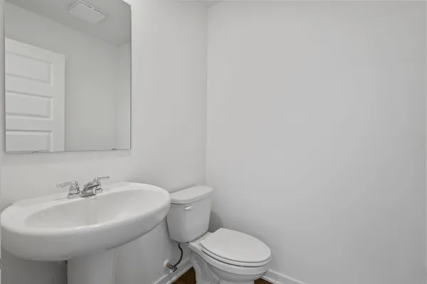 a bathroom with a sink a toilet and mirror
