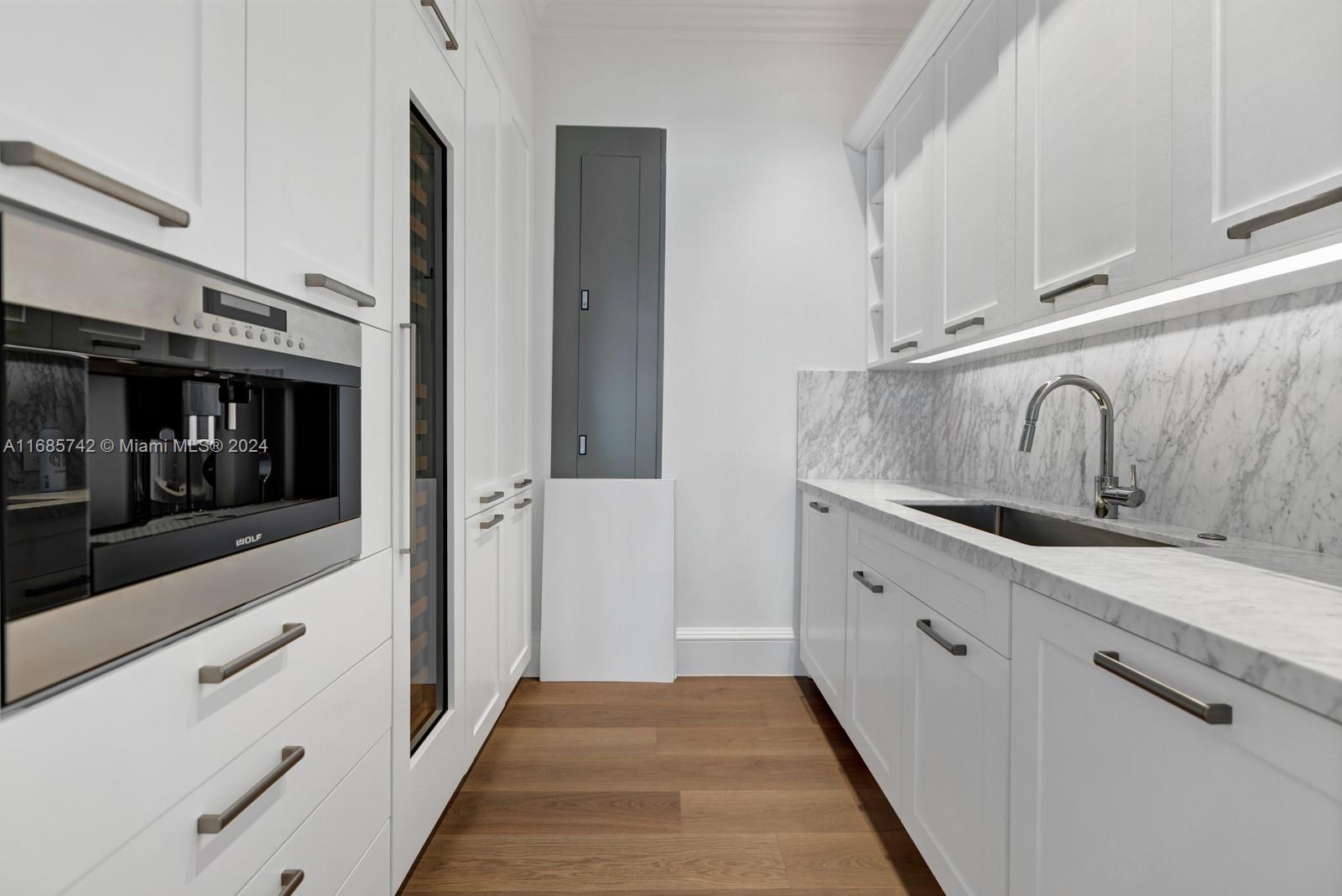 2619 Anderson Road Coral Gables, FL 33134 - Photo 35 of 63 a kitchen with granite countertop white cabinets and stainless steel appliances