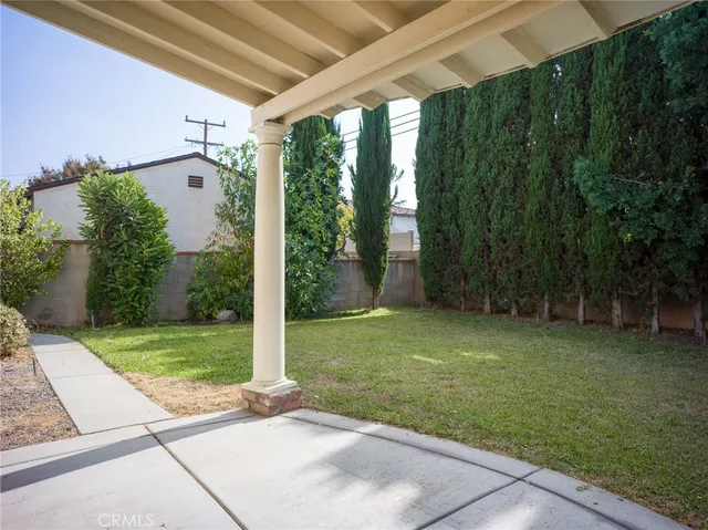 a backyard of a house with plants and large trees