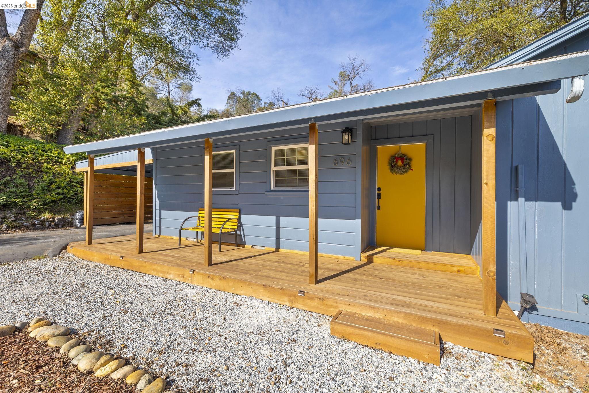 696 Shaws Flat Road Sonora, CA 95370 - Photo 1 of 1 View of front of home with a wooden deck, board and batten siding, and a carport
