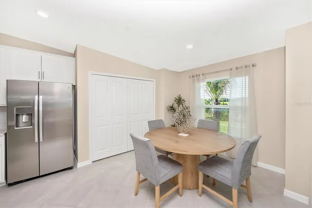 a living room with furniture and a large window with kitchen view