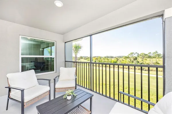 a front view of a house with glass windows and furniture
