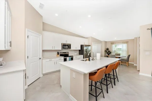a kitchen with stainless steel appliances a table and chairs in it