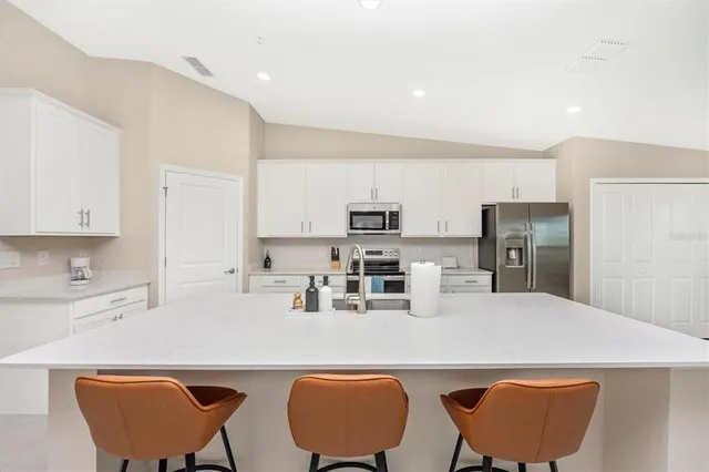 a kitchen with stainless steel appliances a dining table and chairs