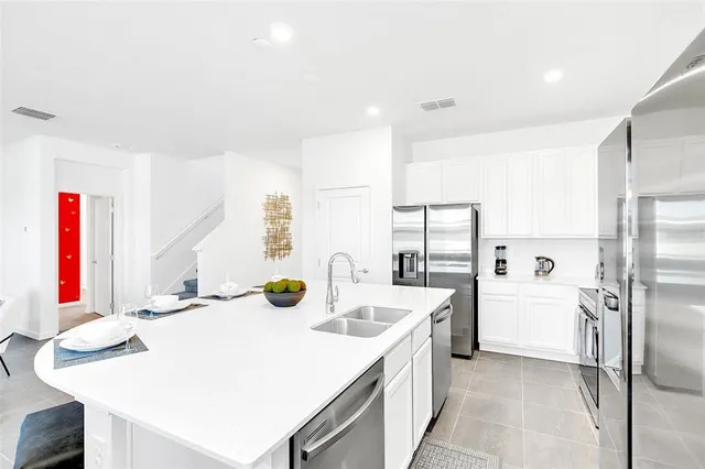 a kitchen with a sink refrigerator and cabinets
