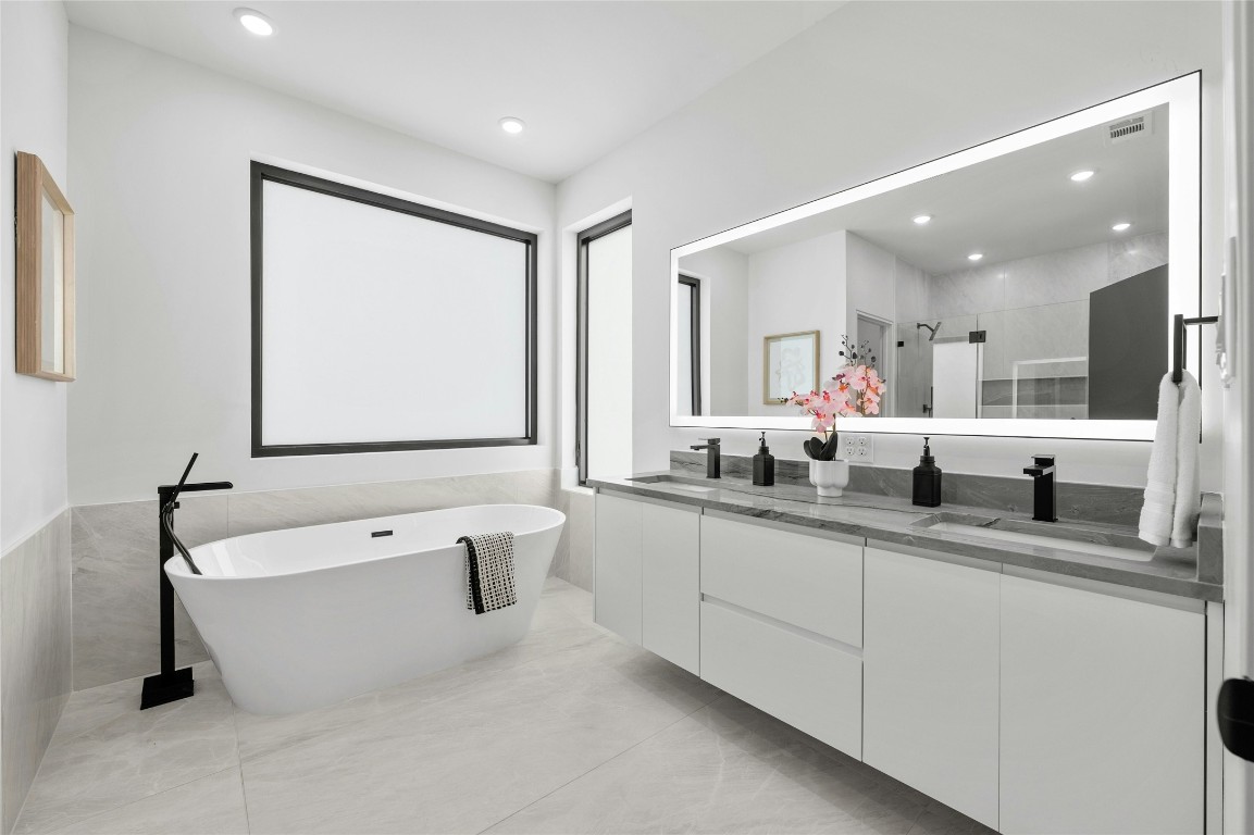 11205 Beach Road Leander, TX 78641 - Photo 24 of 31 a bathroom with a tub a sink and mirror