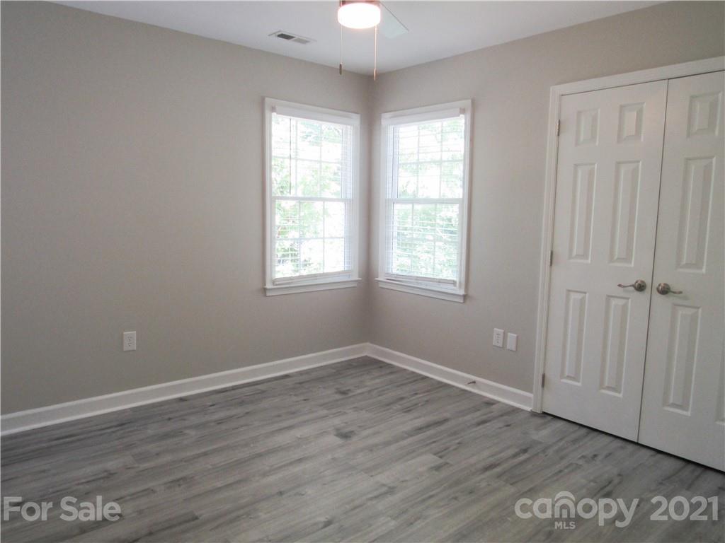112 Comata Road Mooresville, NC 28117 - Photo 11 of 14 an empty room with wooden floor chandelier fan and windows