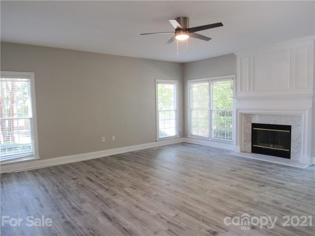 112 Comata Road Mooresville, NC 28117 - Photo 3 of 14 wooden floor fireplace and windows in an empty room