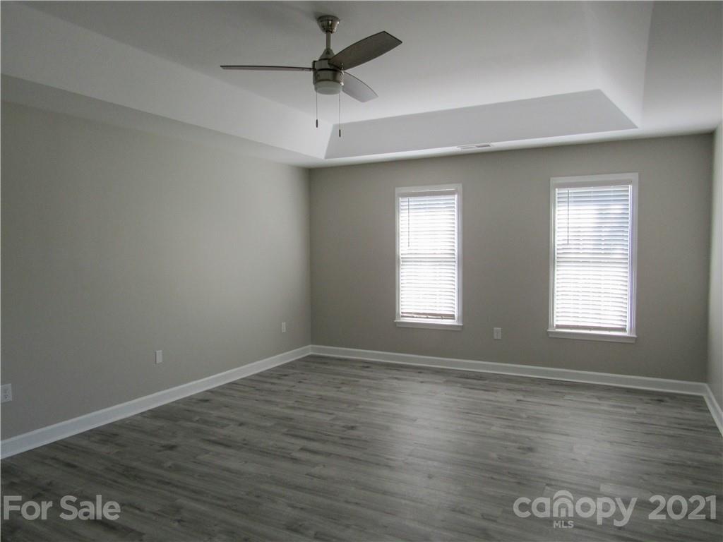 112 Comata Road Mooresville, NC 28117 - Photo 7 of 14 an empty room with wooden floor ceiling fan and windows