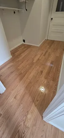 a view of empty room with wooden floor