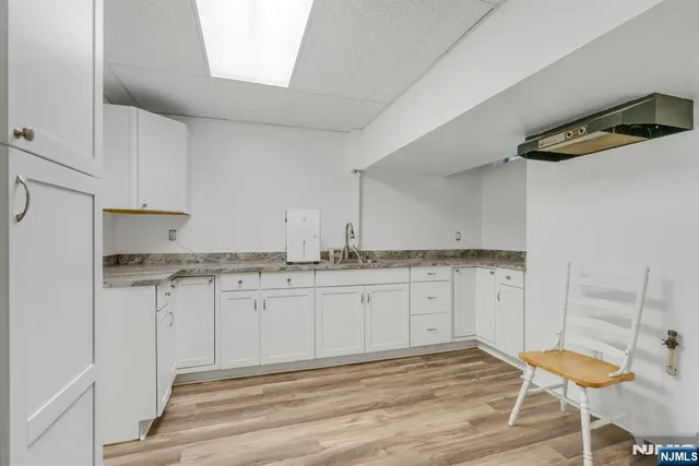 a kitchen with granite countertop white cabinets and white appliances