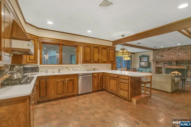 a large white kitchen with stainless steel appliances granite countertop a sink and cabinets