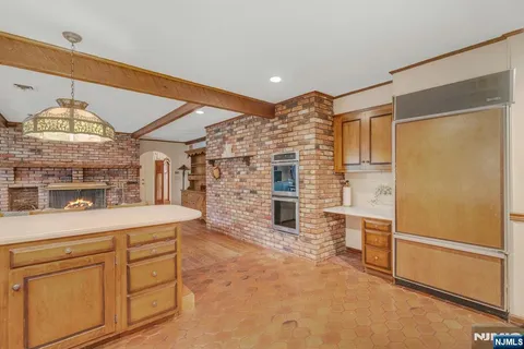 a view of open kitchen with granite countertop cabinets and refrigerator