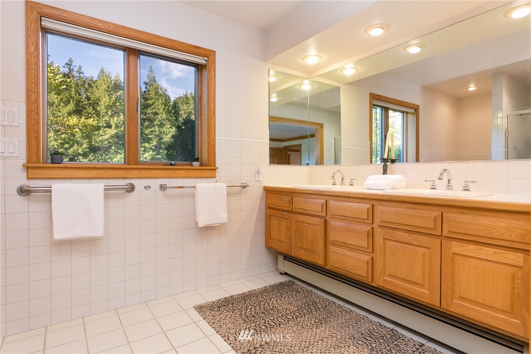 2691 Douglas Road Ferndale, WA 98248 - Photo 22 of 40 a bathroom with a double vanity sink a mirror and a bathtub