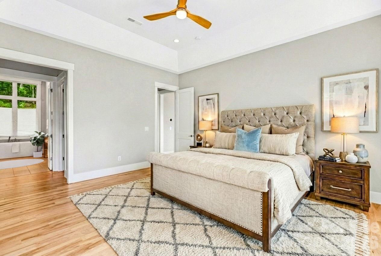 128 Saddle Ridge Drive Alexander, NC 28701 - Photo 16 of 33 a spacious bedroom with a bed and a chandelier
