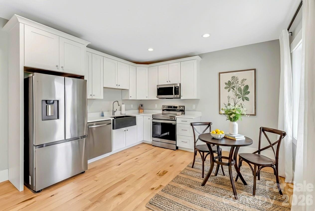 128 Saddle Ridge Drive Alexander, NC 28701 - Photo 23 of 33 a kitchen with granite countertop a refrigerator stove microwave and cabinets