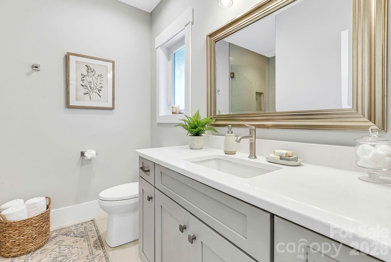 128 Saddle Ridge Drive Alexander, NC 28701 - Photo 26 of 33 a bathroom with a granite countertop toilet sink and mirror