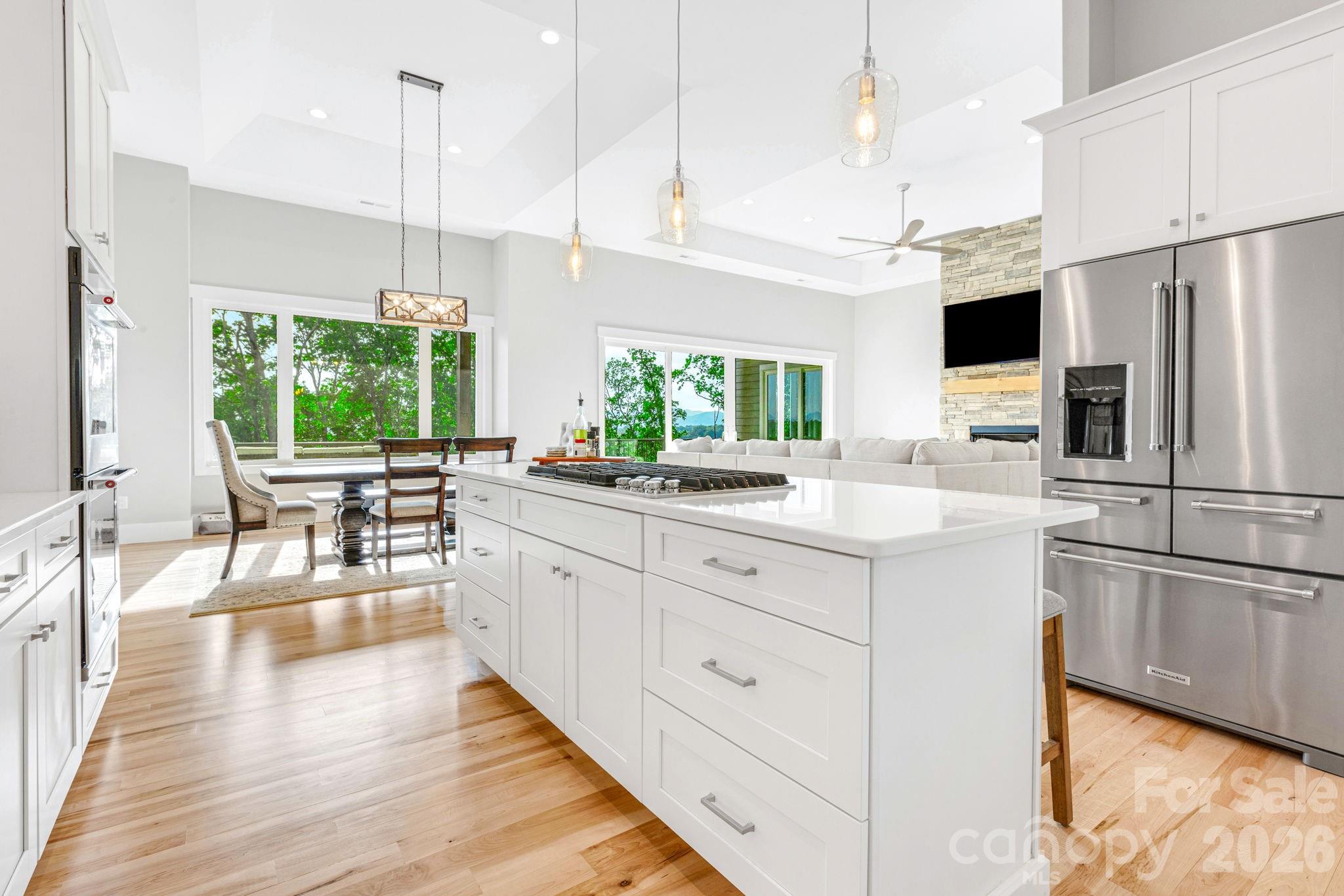 128 Saddle Ridge Drive Alexander, NC 28701 - Photo 4 of 33 a kitchen with stainless steel appliances kitchen island granite countertop a refrigerator a sink dishwasher a oven with white cabinets and wooden floor