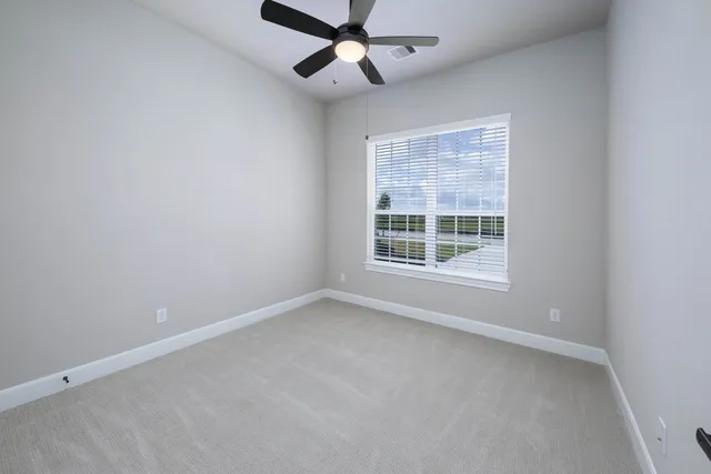 an empty room with a window and a fan