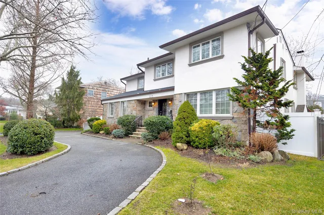 a front view of a house with a yard and potted plants