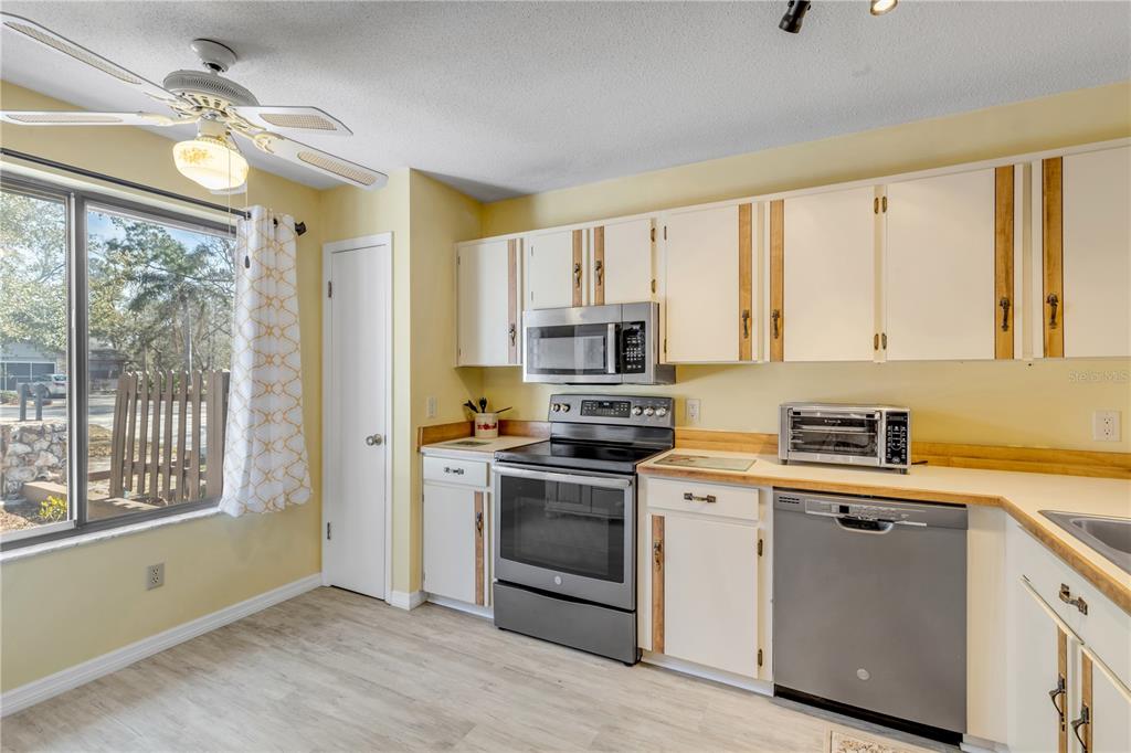 47 Crooked Pine Road Port Orange, FL 32128 - Photo 13 of 41 a kitchen with stainless steel appliances granite countertop a stove a sink and white cabinets with wooden floors