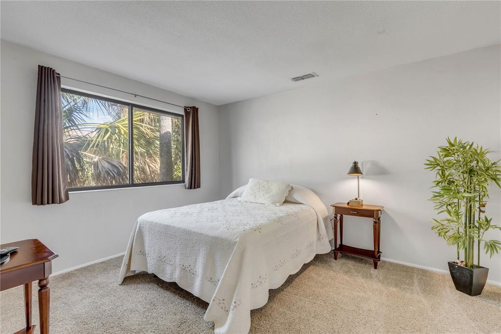 47 Crooked Pine Road Port Orange, FL 32128 - Photo 23 of 41 a bedroom with a bed and a potted plant