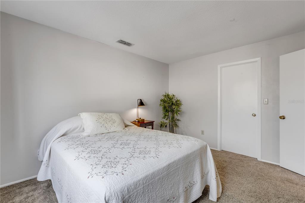 47 Crooked Pine Road Port Orange, FL 32128 - Photo 24 of 41 a bedroom with a bed and a potted plant