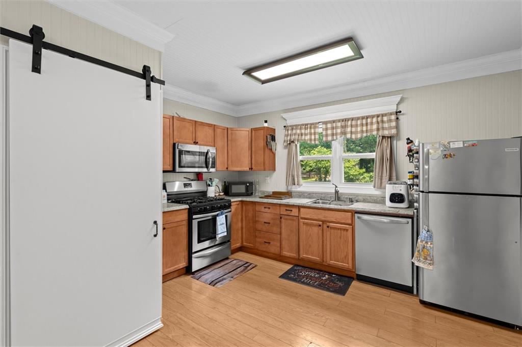 1423 Beulah Church Road Carrollton, GA 30117 - Photo 3 of 31 a kitchen with granite countertop stainless steel appliances a refrigerator stove top oven and sink