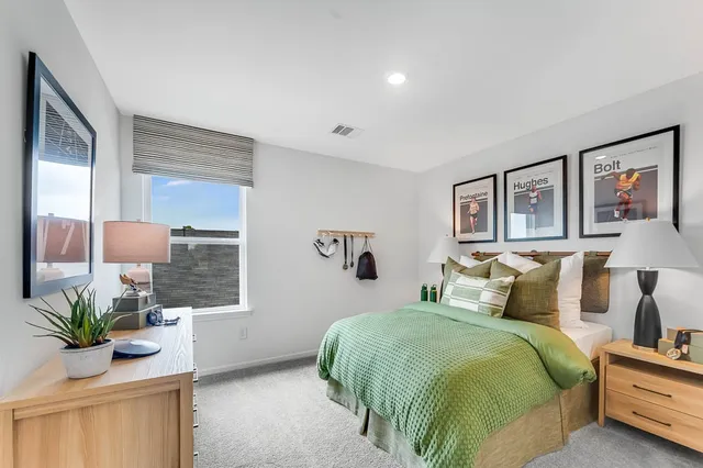 a bedroom with a large bed and wooden floor