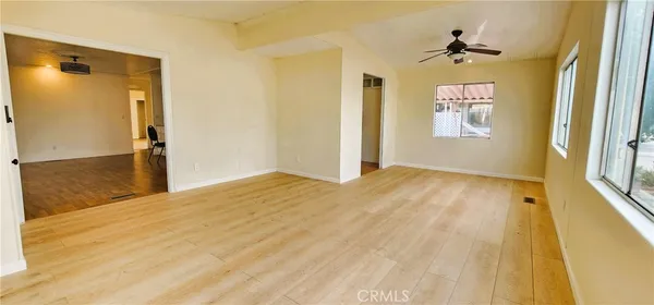a view of a room with wooden floor and windows