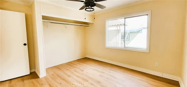 a view of a bedroom with wooden floor and a window
