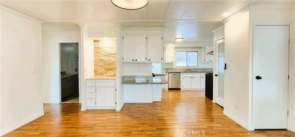 a view of a kitchen with kitchen island white cabinets and stainless steel appliances