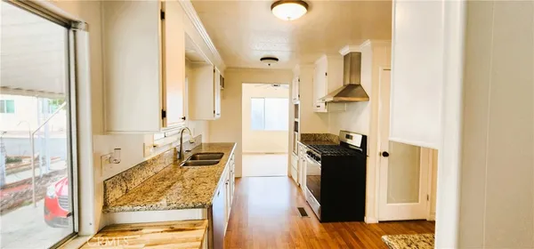 a walk in closet with wooden floor